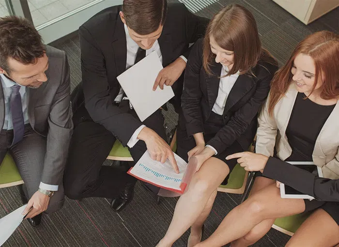 Professionals collaborating around accounting reports and charts during a financial planning session