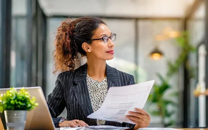 A professional reviews documents with thoughtful strategic analysis